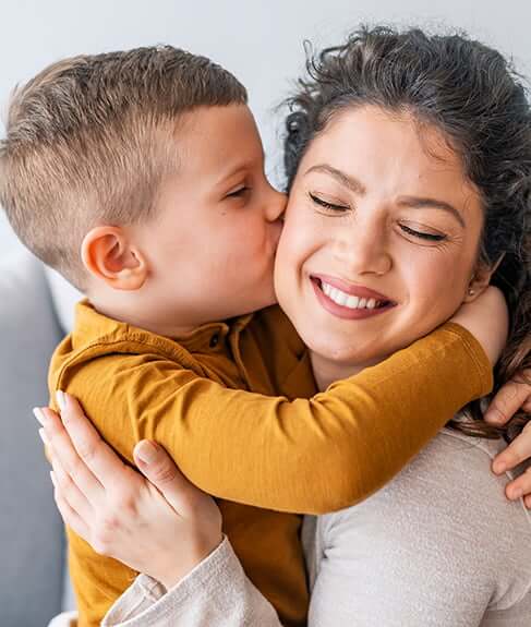 boy kissing his mom on the cheek